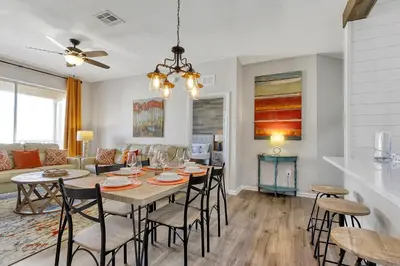 a dining room and living room with a table and chairs at The Perch-2 Miles from Disney, Movie Theatre & Water Park in Orlando