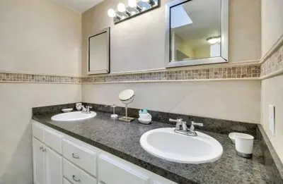 a bathroom with two sinks and a mirror at Florida Gem in Kissimmee