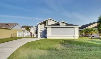 a house with a white garage in a yard at Florida Gem in Kissimmee