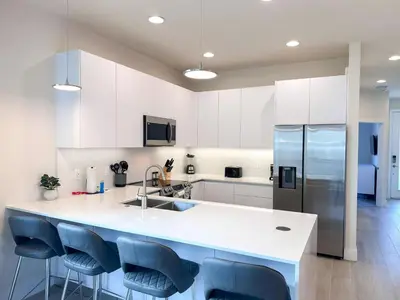 a kitchen with a white counter and blue chairs at TR1421SL - Brand new Mykonos property in Orlando