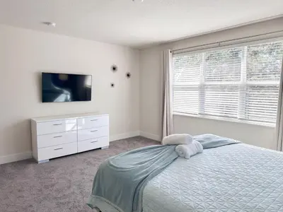a bedroom with a bed and a tv and a window at TR1421SL - Brand new Mykonos property in Orlando