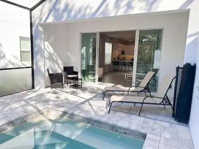 a patio with chairs and a swimming pool at TR1421SL - Brand new Mykonos property in Orlando