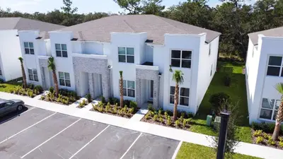 a large white house with palm trees in a parking lot at TR1421SL - Brand new Mykonos property in Orlando