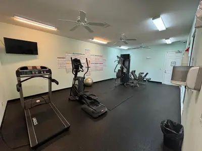 a gym with several exercise equipment in a room at Family stay Near Disney in Kissimmee