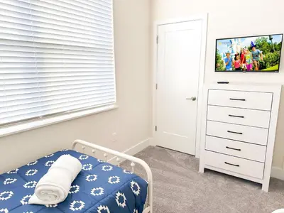 a bedroom with a bed and a dresser with a tv at TR1399 – 4BR - 8 guests in Orlando