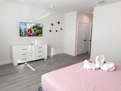 a bedroom with a bed and a dresser with two towels at TR1391 – 4 Bedrooms Home with pool near Disney in Clermont