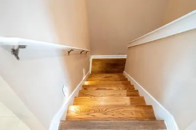 a staircase with wooden floors in a room at Disney Escape Modern 3BR Townhouse 2 Miles to the Parks 4 Baths in Orlando
