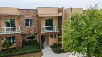 an apartment building with balconies and a tree at Disney Escape Modern 3BR Townhouse 2 Miles to the Parks 4 Baths in Orlando