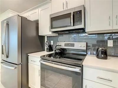 a kitchen with a stove and a stainless steel refrigerator at Beautiful 3bed 2bath Condo close to Disney Parks 344 in Kissimmee