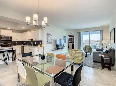 a kitchen and living room with a glass table and chairs at Beautiful 3bed 2bath Condo close to Disney Parks 344 in Kissimmee