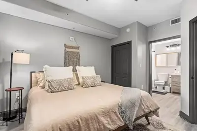 a bedroom with a large white bed with pillows at LUXURY 1br LAKEVIEW CONDO NEAR DISNEY! in Orlando