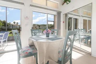 a table and chairs with a vase of flowers on it at Family Home w/ Pool & Water Views, Near Disney in Kissimmee