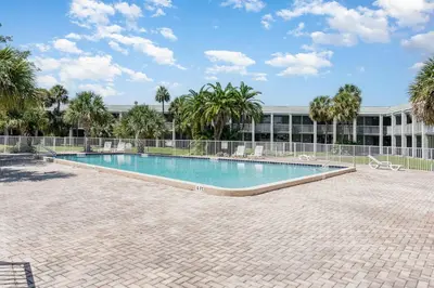 a swimming pool in front of a building at Charming Suite: Smart TV, Modern Amenities & Pool Access in Kissimmee