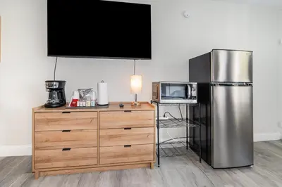 a kitchen with a stainless steel refrigerator and a microwave at Charming Suite: Smart TV, Modern Amenities & Pool Access in Kissimmee