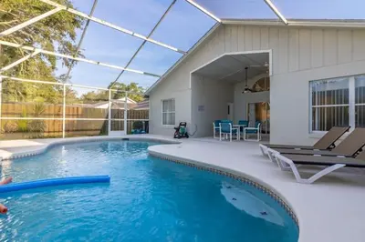 a swimming pool with two chairs and a house at Indian Ridge Home w/ Private Pool & Game Room near Disney in Orlando