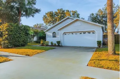 a house with a garage with a driveway at Indian Ridge Home w/ Private Pool & Game Room near Disney in Orlando
