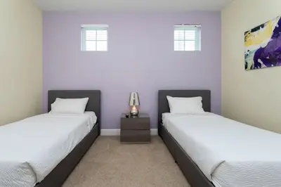 two beds in a room with purple walls at 421 NP - Exquisite Retreat at Encore Resort in Orlando