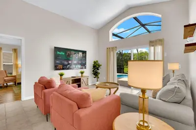 a living room with pink furniture and a window at Stunning Emerald Island Resort Vacation Home with Pool Spa and Access to Clubhouse in Kissimmee