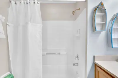 a bathroom with a shower with a white shower curtain at Stunning Emerald Island Resort Vacation Home with Pool Spa and Access to Clubhouse in Kissimmee