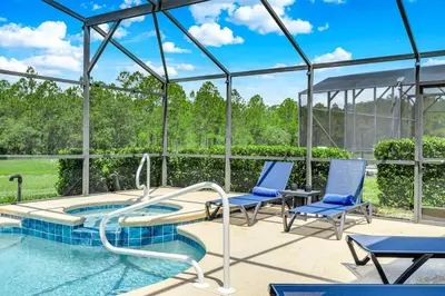 a swimming pool with two chairs and a slide at Stunning Emerald Island Resort Vacation Home with Pool Spa and Access to Clubhouse in Kissimmee