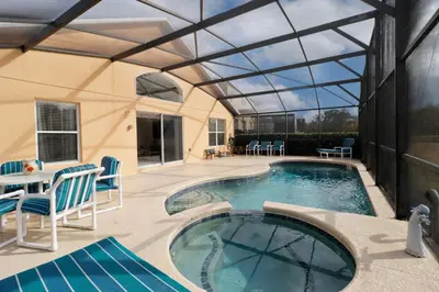 a swimming pool with a glass roof and a patio at Stunning Emerald Island Resort Vacation Home with Pool Spa and Access to Clubhouse in Kissimmee