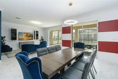a dining room with a wooden table and blue chairs at Fantastic Home 7BR5BA with Private Pool Storey Lake Resort SL2648 in Kissimmee
