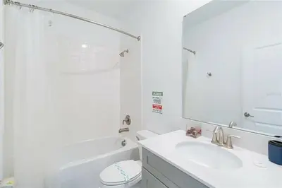 a bathroom with a sink and a toilet and a mirror at Fantastic Home 7BR5BA with Private Pool Storey Lake Resort SL2648 in Kissimmee