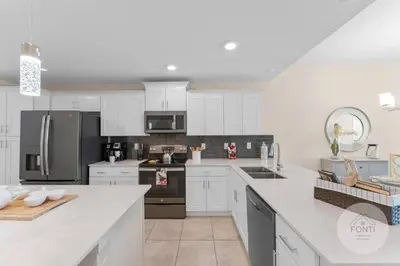 a kitchen with white cabinets and stainless steel appliances at 3141-104 Resort Lake View Disney Universal Orlando in Kissimmee
