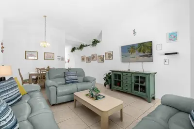a living room with couches and a flat screen tv at Upstay - Games & Private Pool Family Home in Orlando