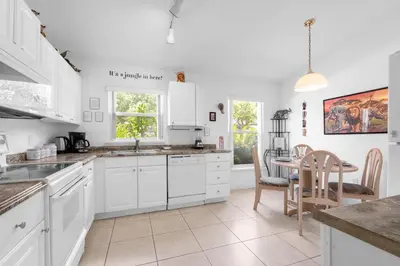 a kitchen with white cabinets and a table at Upstay - Games & Private Pool Family Home in Orlando