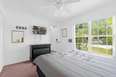 a bedroom with a bed and a tv and a window at Upstay - Games & Private Pool Family Home in Orlando