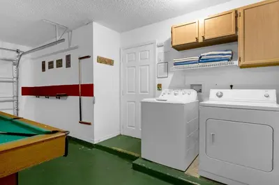 a laundry room with a washer and dryer and a pool table at Upstay - Games & Private Pool Family Home in Orlando