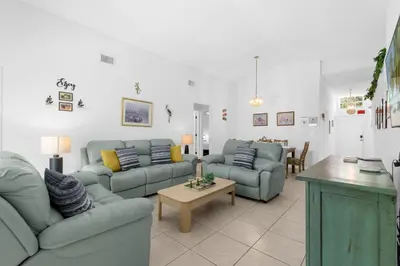 a living room with two couches and a table at Upstay - Games & Private Pool Family Home in Orlando