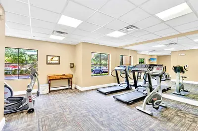 a fitness room with treadmills and elliptical machines at Suite with Pool and Hot Tub - Close to Near Disney in Orlando