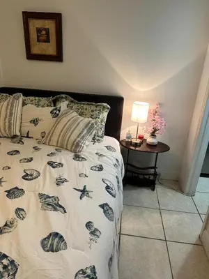 a bedroom with a bed and a table with a lamp at Private Studio in Kissimmee