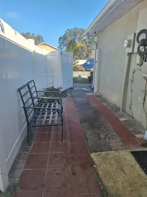 a pair of benches sitting on a sidewalk next to a fence at Private Studio in Kissimmee