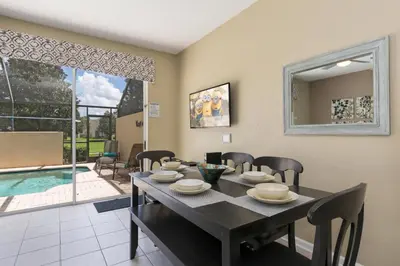 a dining room with a table and chairs and a pool at Escape to Luxury in Orlando Villa6492 in Orlando