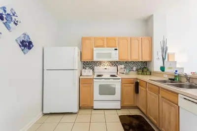 a kitchen with white appliances and wooden cabinets at Cozy 3 Bedroom Haven in Orlando6497 in Orlando