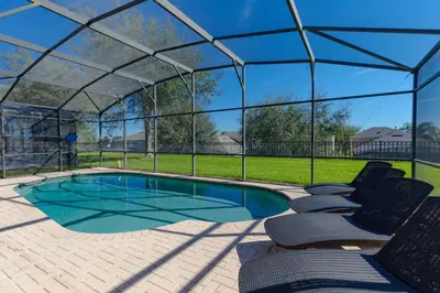 a swimming pool in a greenhouse with chairs around it at Orlando Dream Home - 4 Bed Villa6501 in Orlando
