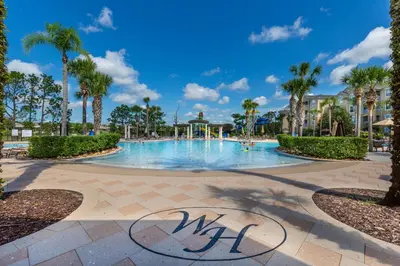 a swimming pool at a resort with palm trees at Orlando Oasis: 5 Bedroom Villa6502 in Orlando