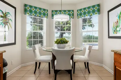 a dining room with a table and chairs and windows at Orlando Oasis: 5 Bed Villa6504 in Orlando