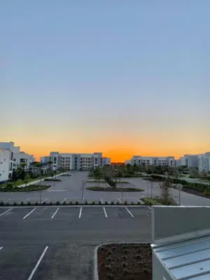 an empty parking lot with a sunset in the background at Brand New Luxury 2bd 2 bath Condo Home 270 in Kissimmee