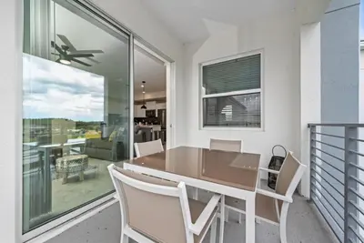 a dining room with a table and chairs on a balcony at Luxury 2bd 2 bath Condo Home 254 in Kissimmee
