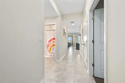 a hallway with white walls and a rainbow painting on the wall at Luxury 2bd 2 bath Condo Home 254 in Kissimmee