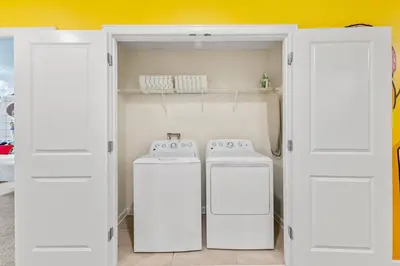 two washing machines in a laundry room with white doors at 2869 Epic Themed Mega Home at Storey Lake 7DB in Kissimmee