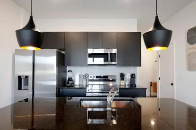 a kitchen with stainless steel appliances and black cabinets at New great townhouse in The Hub in Kissimmee