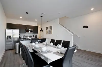 a dining room with a white table and black chairs at New great townhouse in The Hub in Kissimmee