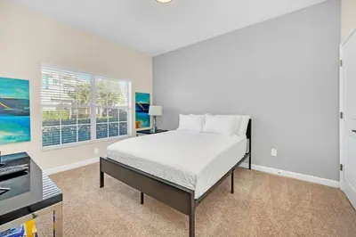 a bedroom with a bed and a desk and a window at Heated pool Lazy River Mini Golf Near Disney Resort in Kissimmee