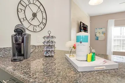 a kitchen counter with a blender and a clock on the wall at Heated pool Lazy River Mini Golf Near Disney Resort in Kissimmee