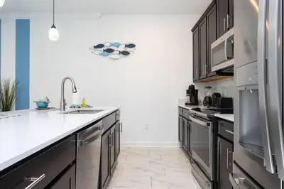 a kitchen with stainless steel appliances and black cabinets at 4Q/3B Storey Lake Resort, melhor localização! in Kissimmee